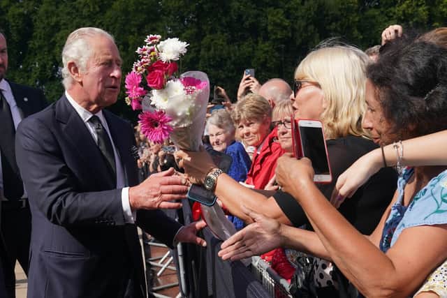 King Charles III is greeted by well-wishers during a walkabout to view tributes left outside Buckingham Palace, London, following the death of Queen Elizabeth II on Thursday.  Photo credit: Yui Mok/PA Wire