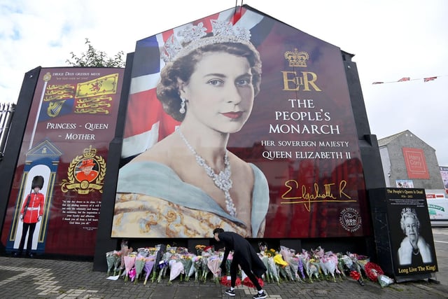 Laying flowers at Queen Elizabeth II mural on the Shankill Road