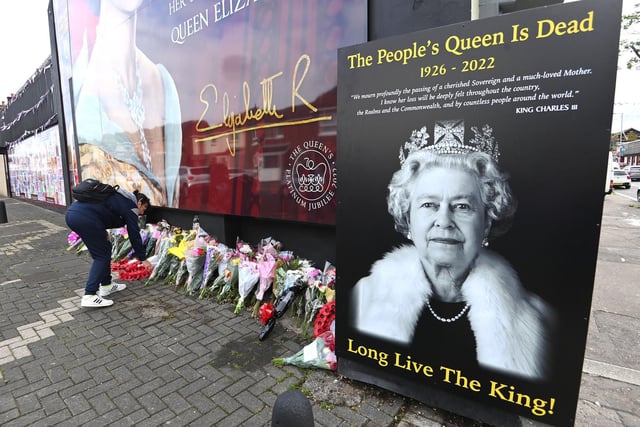 Laying flowers at Queen Elizabeth II mural on the Shankill Road