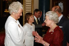 Queen Elizabeth II talks to Olympic gold medallist Dame Mary Peters as the Duke of Edinburgh speaks to former gold medallist figure skater Jayne Torville