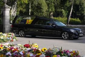The hearse carrying the coffin of Queen Elizabeth II, draped with the Royal Standard of Scotland, leaving Balmoral as it begins its journey to Edinburgh
