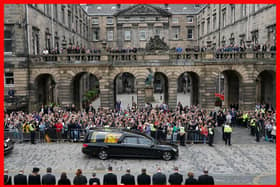 Crowds watch as the hearse carrying the coffin of Queen Elizabeth II, draped with the Royal Standard of Scotland, passes Mercat Cross in Edinburgh, as it continues its journey to the Palace of Holyroodhouse from Balmoral