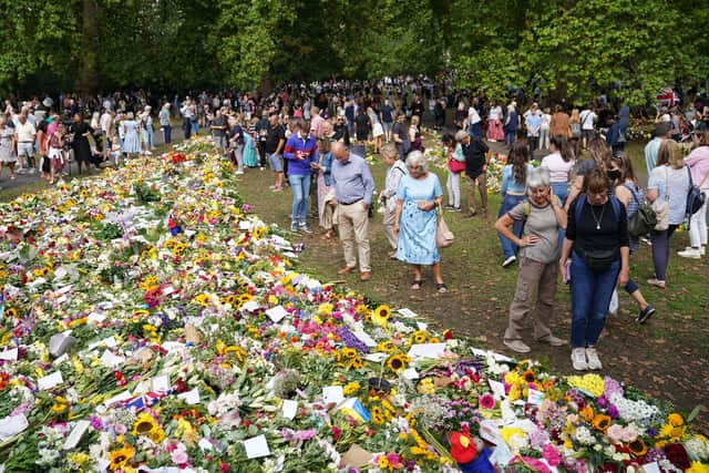 Members of the public view floral tributes in Green Park, near Buckingham Palace, London following the death of Queen Elizabeth II on Thursday. Picture date: Monday September 12, 2022.