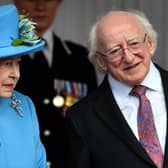 Queen Elizabeth II stands with Irish President Michael D. Higgins (R) during a ceremonial welcome for him in Windsor in 2014.