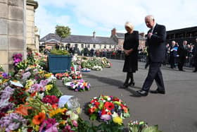 King Charles III and the Queen Consort look at floral tributes as they arrive at Hillsborough Castle, Co Down. Picture date: Tuesday September 13, 2022.