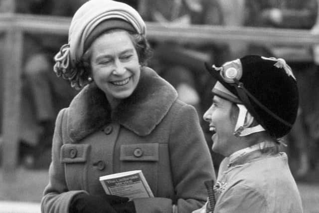The Queen sharing a joke with jockey Willie Carson in the paddock before he rode Sea Boat to third place in the Ladbroke Racing Handicap at Newmarket.