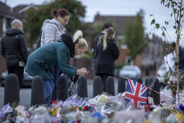 A woman looks at the tributes on the Shankill Road in west Belfast before last night’s minute’s silence