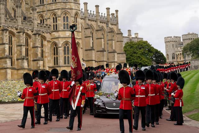 The State Hearse carries the coffin of Queen Elizabeth II, draped in the Royal Standard with the Imperial State Crown and the Sovereign's Orb and Sceptre, during the Ceremonial Procession through Windsor Castle to a Committal Service at St George's Chapel