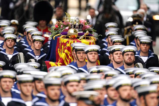 The State Gun Carriage carries the coffin of Queen Elizabeth II, draped in the Royal Standard with the Imperial State Crown and the Sovereign's orb and sceptre, in the Ceremonial Procession during her State Funeral at Westminster Abbey, London