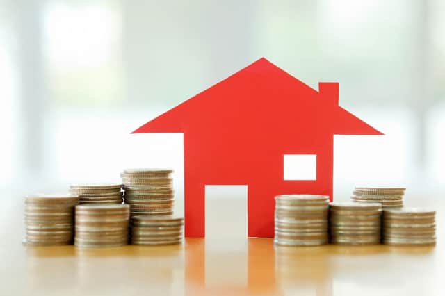 A generic photo of a red house with stacks of coins around it. Picture credit: PA Photo/thinkstockphotos.