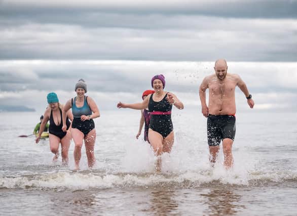  Alison Black, Jenny Moore, Sarah Black and stephen Moore were among hundreds of swimmers came to Crawfordsburn beach today to take part in the annual Cancer Focus NI Dare to Dip event raising money and awareness for the charity.  Picture by Brian Morrison.