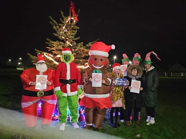 Pictured celebrating the arrival of the Christmas tree are Dhu Varren residents and local business owners Leeanne Montgomery, Louise Vickers, Aimee Anderson, Declan Anderson, Biddy Fleming, Claire Cairns, Jessica Mitchell and Elizabeth Brown