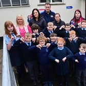 Kingsmills Primary School Principal Gemma Harrison (in green dress, far right) along with, parents and pupils, who are giving a 'thumbs down' to plans by The Education Authority to close the school in August.