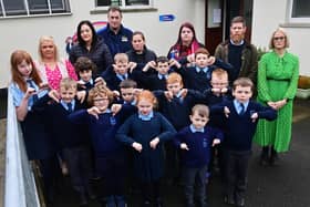 Kingsmills Primary School Principal Gemma Harrison (in green dress, far right) along with, parents and pupils, who are giving a 'thumbs down' to plans by The Education Authority to close the school in August.