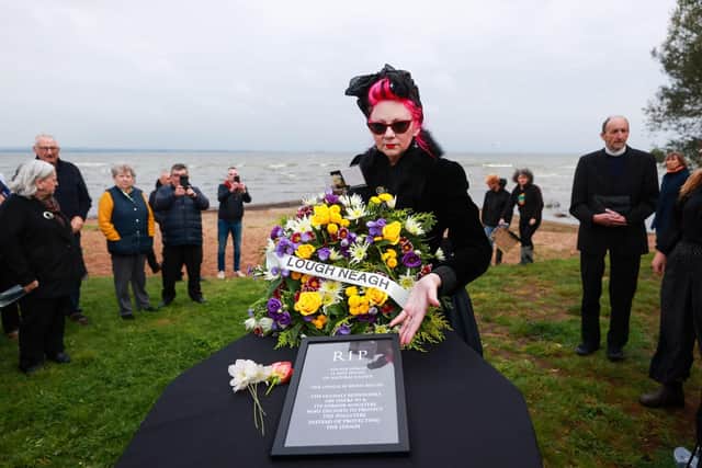 Sue Bamford places a wreath on a box symbolising a coffin as environmental campaigners hold a "wake" at Ballyronan beach for Lough Neagh lake amid claims toxic algae is killing the UK and Ireland's largest freshwater lake. Picture date: Sunday September 17, 2023.