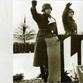 Nazi soldiers saluting at a podium bearing SS insignia; the SS was one of the agencies most responsible for the Jewish Holocaust