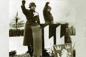 Nazi soldiers saluting at a podium bearing SS insignia; the SS was one of the agencies most responsible for the Jewish Holocaust