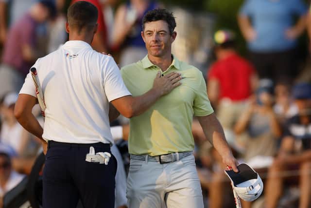 Rory McIlroy of Northern Ireland and Wyndham Clark of the United States shake hands on the 18th green during the third round of the TOUR Championship at East Lake Golf Club. PIC: Cliff Hawkins/Getty Images