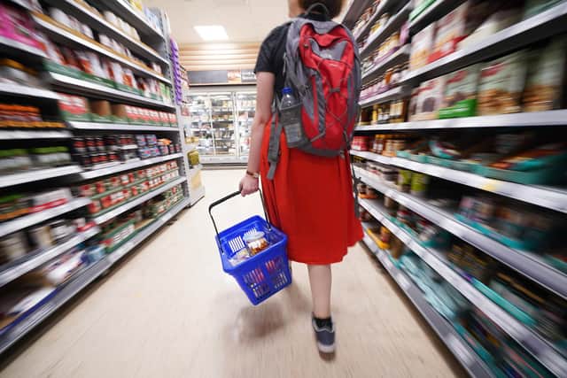 File photo dated 03/09/22 of a shopper walking through the aisle of a Tesco supermarket, as food inflation has accelerated to record levels