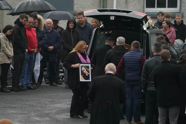 Leona Harper's mother Donna carries a photo of her as her coffin arrives at St Mary's Church in Ramelton, Co Donegal, for her the funeral mass.