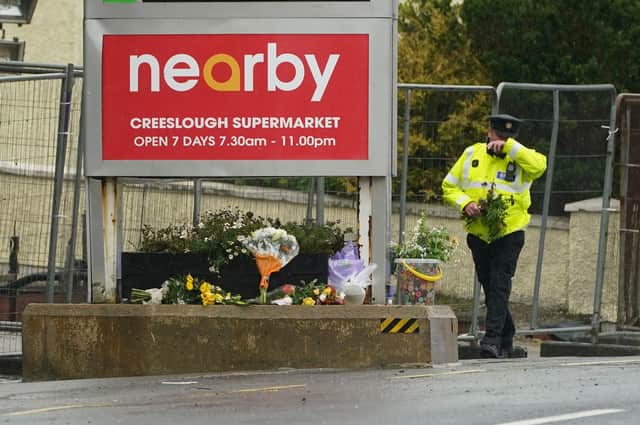 A member of An Garda brings flowers to the scene of an explosion at Applegreen service station in the village of Creeslough in Co Donegal, where ten people have now been confirmed dead. Picture date: Sunday October 9, 2022.