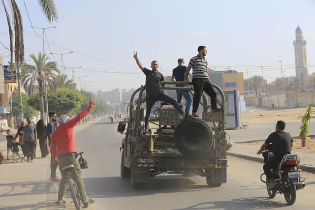 Palestinians ride on an Israeli military vehicle taken by an army base overrun by Hamas terrorists near the Gaza Strip fence, in Gaza City, Saturday (AP Photo/Abed Abu Reash)