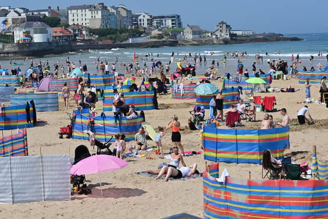 Crowds enjoy the hot weather at Portrush beach on Monday.
