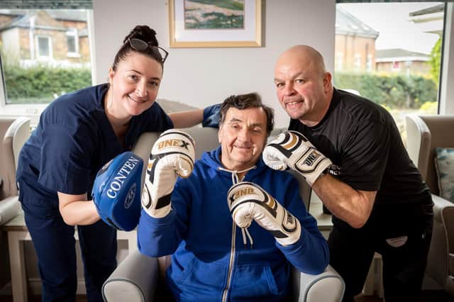 Residents at a care home in East Belfast are taking a fun and novel approach to keeping fit. Pictured from left to right: De la Cour Manager House Tammy Forsyth, resident Sammy Johnston and boxing coach Joe Harvey.