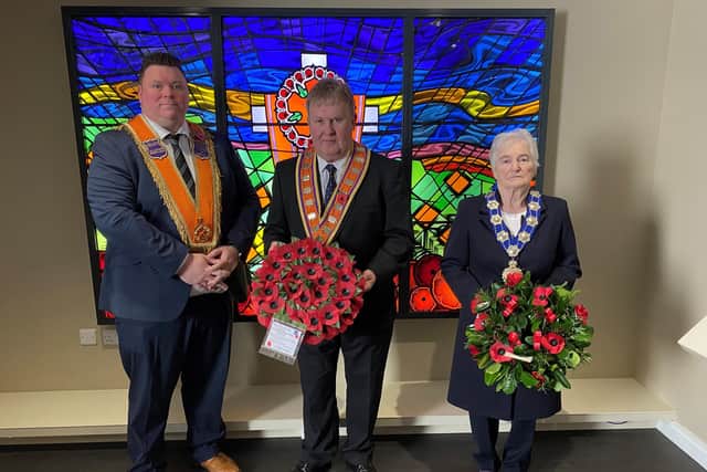Deputy Grand Master Rt. Wor. Bro. Harold Henning lays a wreath at the Memorial Window in Schomberg House with Grand Mistress Wor. Sis. Joan Beggs and Junior Grand Master Wor. Bro. Joe Magill.