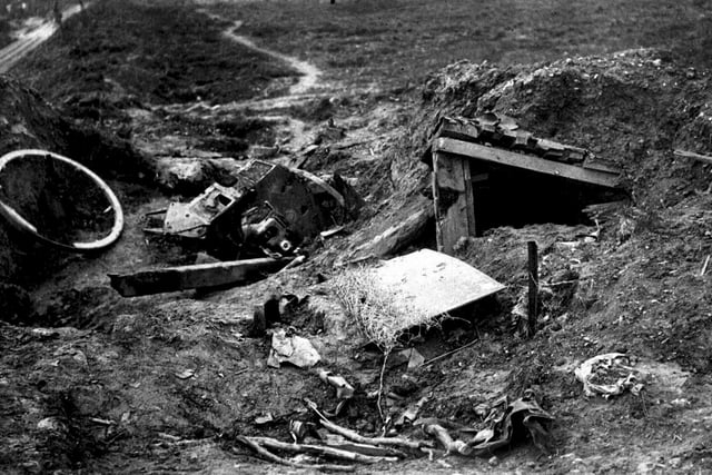 1916: A German field gun and its emplacement wrecked by artillery fire during the Battle of the Somme. A dug out can be seen to right.:-