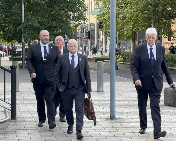 A challenge to the decision to stop the Drumcree parade made by Chris Bryant returns to court today.  Loyalist activist Jamie Bryson (centre), along with leading members of the Portadown District of the Orange Order, arrive at the High Court in Belfast for an earlier hearing.