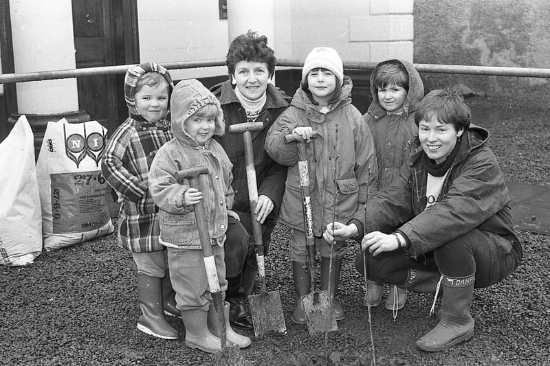 Digging in: Tiny tots from Doagh Mothers and Toddlers Group plant cherry tree saplings in the grounds of Doagh Methodist Church with help of leader Jane McKendry and founder member Maureen Duddy in March 1992. The trees marked the group’s tenth anniversary. Picture: News Letter archives
