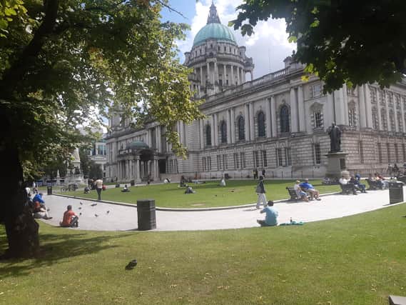 People enjoy the summer sunshine in the grounds of Belfast City Hall at lunchtime yesterday.  Pic Ben Lowry