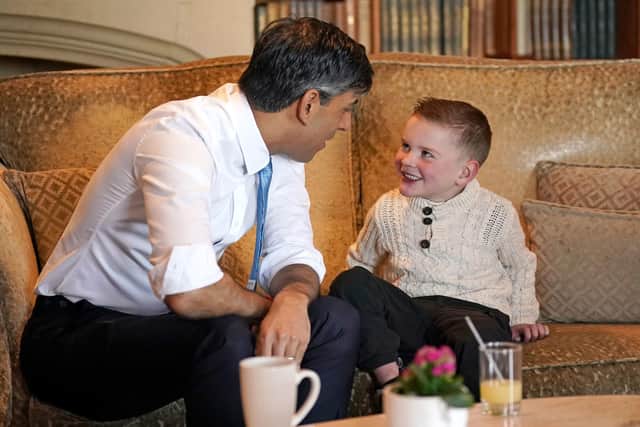 Prime Minister Rishi Sunak presents six-year-old Daithi Mac Gabhann, who is awaiting a heart transplant, with an award recognising "outstanding volunteers" for his contribution to his community