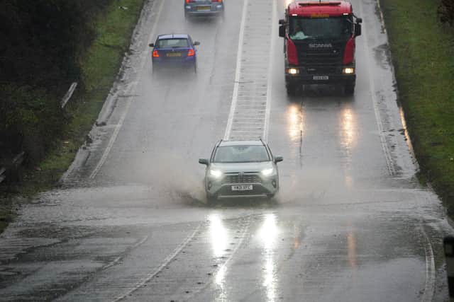 Vehicles driving through service water on a flooded part of the A37 near Bristol. Ben Birchall/PA Wire