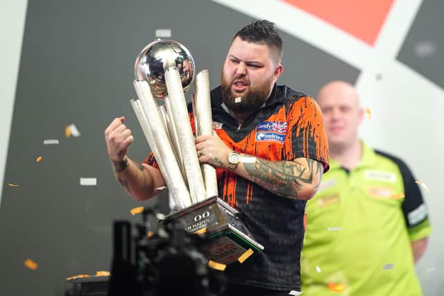 Michael Smith celebrates with the Sid Waddell trophy after winning the final of the Cazoo World Darts Championship against Michael van Gerwen at Alexandra Palace, London.