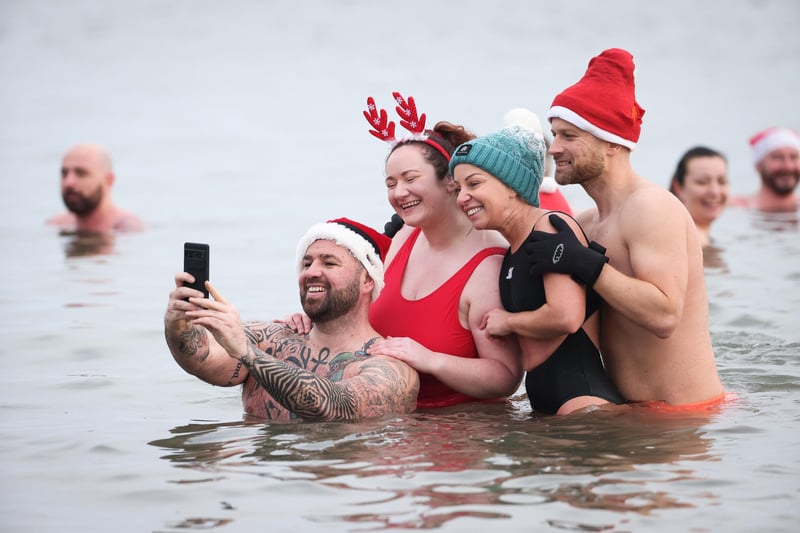 Ciaran May and swimmers from Natural Resilience join swimmers from north Down take part in the annual Santa Splash at Helens Bay beach, County Down.