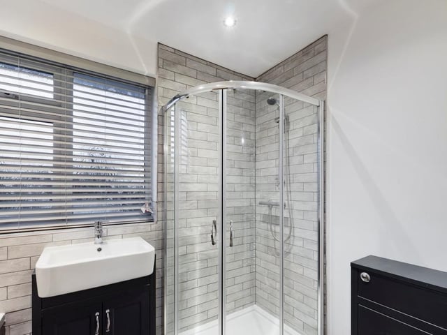 Newly refitted, the modern bathroom features a shower enclosure, with a thermostatic shower and glazed door. The vanity wash hand basin includes a storage cupboard underneath.