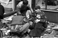 A British paratrooper takes a young girl in his arms to comfort her after she was hurt in a 1972 bomb blast in Donegal Street, Belfast. Photo: Derek Brind/PA Archive