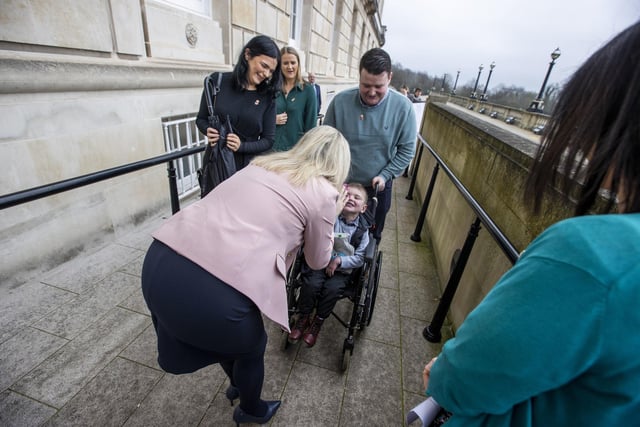 Six-year-old Daithi Mac Gabhann and his parents, father Mairtin Mac Gabhann (right) and mother Seph Ni Mheallain (left) are greeted by Sinn Fein Vice President Michelle O'Neill  as they arrive at Parliament Buildings at Stormont