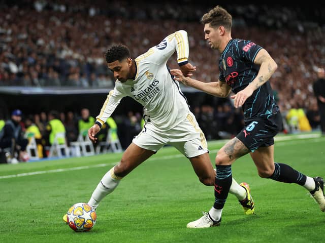 Real Madrid's Jude Bellingham challenged by John Stones in the Champions League draw with Manchester City. (Photo by Clive Brunskill/Getty Images)