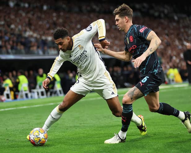 Real Madrid's Jude Bellingham challenged by John Stones in the Champions League draw with Manchester City. (Photo by Clive Brunskill/Getty Images)