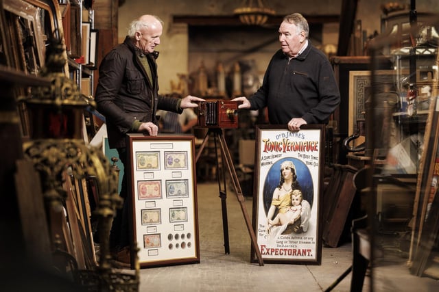 Victor Mee of Victor Mee Auctions with Gerard Derry of Derrys Furniture, Armagh with framed Lady Lavery collectable original coins and bank notes, an early 20th century instant full plate field camera and a original Dr D Jaynes tonic poster