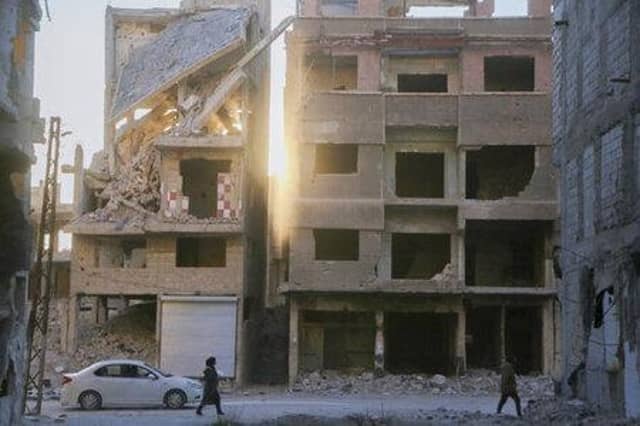 The scale of destruction is laid bare at apartment blocks in Yarmouk camp outside Damascus, Syria, reduced to rubble following an airstrike