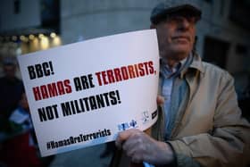A member of the Jewish community holds a poster outside BBC Broadcasting House in London earlier this week to demonstrate against the BBC's ongoing refusal to label Hamas as terrorists. The BBC's John Simpson claimed that the word choice is down to the fact that “We [the BBC] don't take sides.” Hamas was prescribed as a terrorist organisation by the UK in March 2021