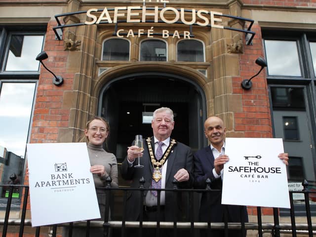 A former bank building in Portrush has been brought back to life following a £2.5m restoration project. The listed building, originally built in 1898 for the Belfast Banking
Company, has been converted to serviced apartments and a café bar by Andras Hotels, Northern Ireland’s largest hotel group. Pictured are Causeway Coast and Glens Council mayor Cllr Steven Callaghan is the guest of honour at the official launch of the Bank Apartments and the Safehouse Cafe Bar in Portrush pictured with Cafe Bar manager Natasha Kirke and Rajesh Rana, director of the Andras House Hotel Group