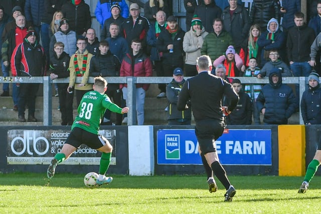 Niall McGinn fires in his - and Glentoran's - second of the match against Carrick Rangers at the Loughview Leisure Arena as the away fans watch on