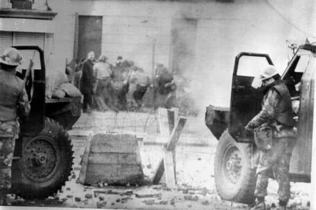 Soldiers taking cover behind their sandbagged armoured cars while dispersing rioters with CS gas in Londonderry, where an illegal civil rights march culminated in a clash between troops and demonstators, which resulted in 13 men being shot dead.