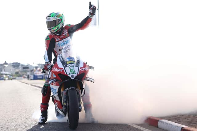 Glenn Irwin celebrates with a one-handed burnout after winning the feature NW200 Superbike race for a unique treble