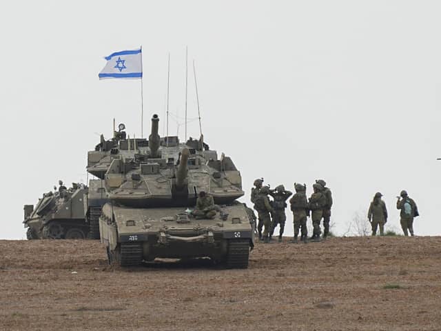 Israeli soldiers are seen in a staging ground near the Israeli Gaza border, southern Israel, on Monday